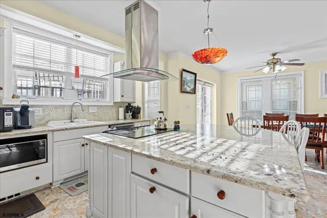 a kitchen with stainless steel appliances granite countertop a stove a sink and white cabinets