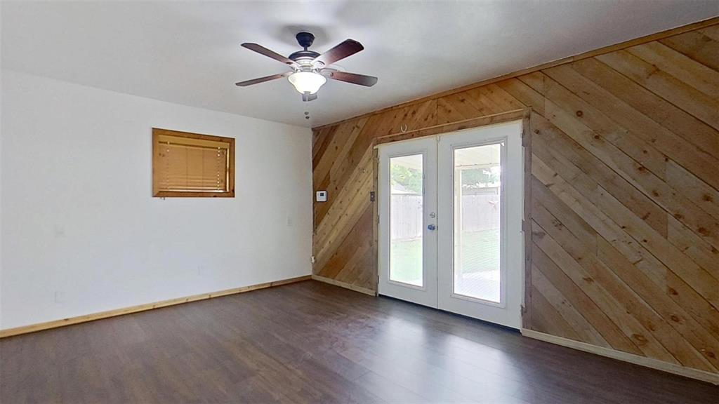 900 Silver Creek Azle Road Azle, TX 76020 - Photo 16 of 27 Wood-finish flooring with an adjacent white wall and a diagonal wood-paneled accent wall