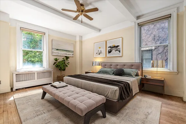 a bedroom with a bed couches and window