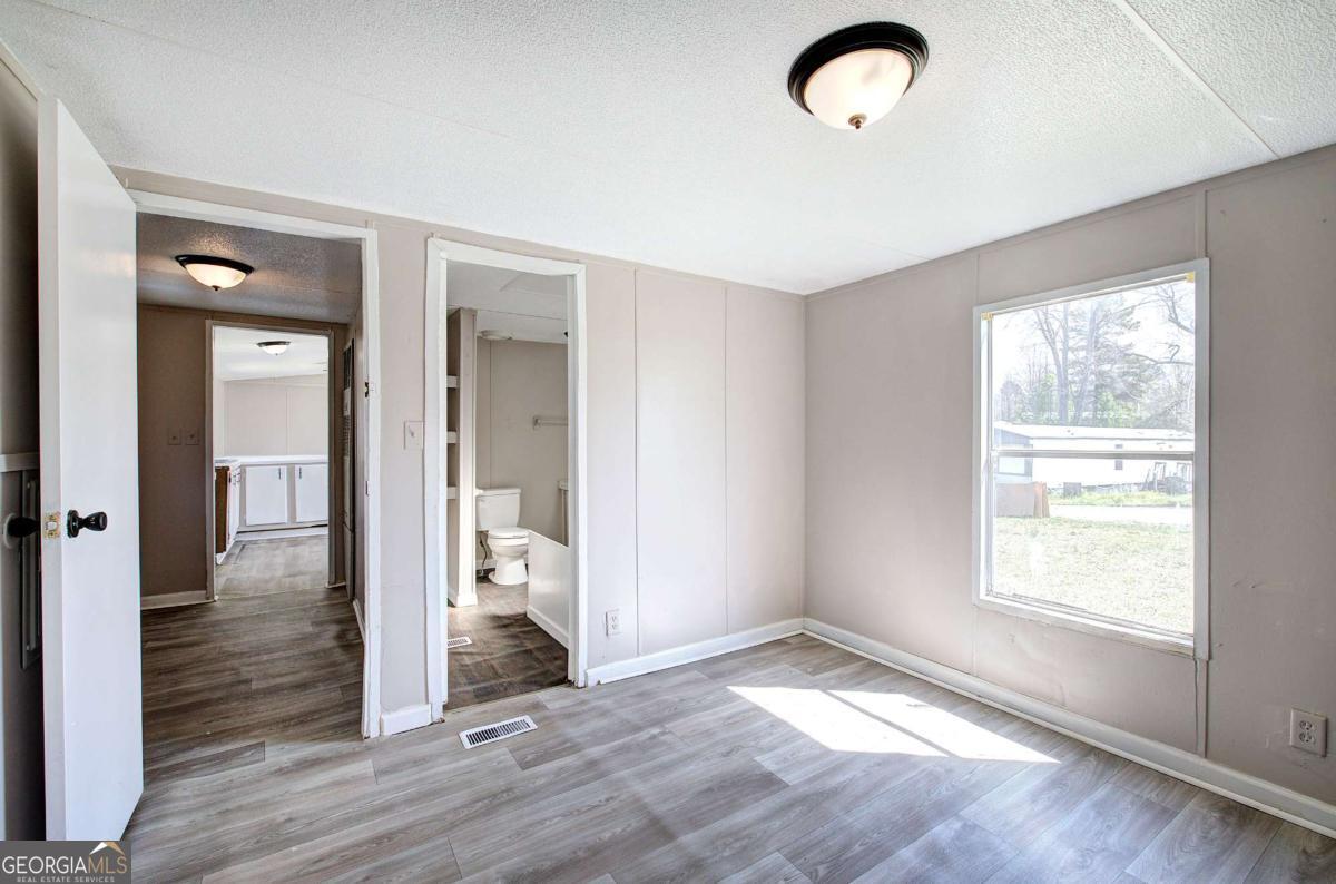 14 High Bluff Road Northeast Rome, GA 30165 - Photo 18 of 29 an empty room with wooden floor and windows