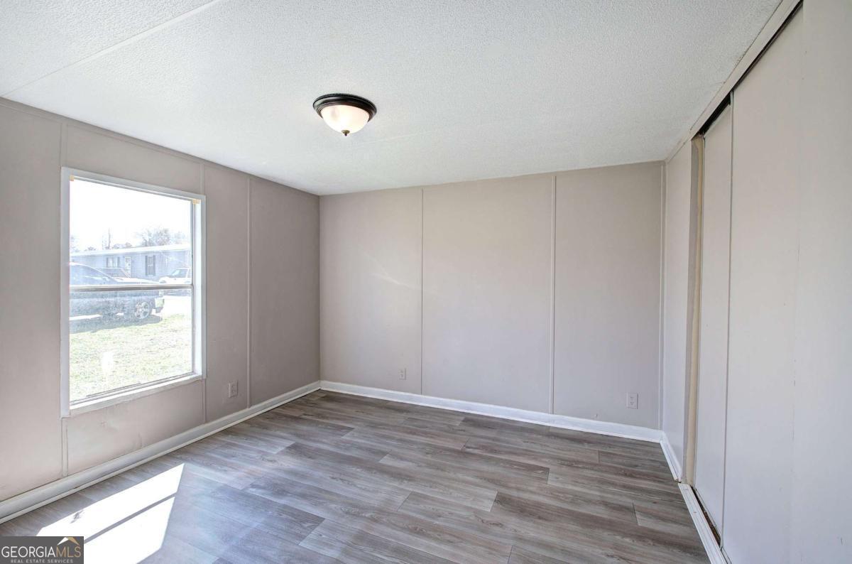 14 High Bluff Road Northeast Rome, GA 30165 - Photo 19 of 29 an empty room with wooden floor and windows