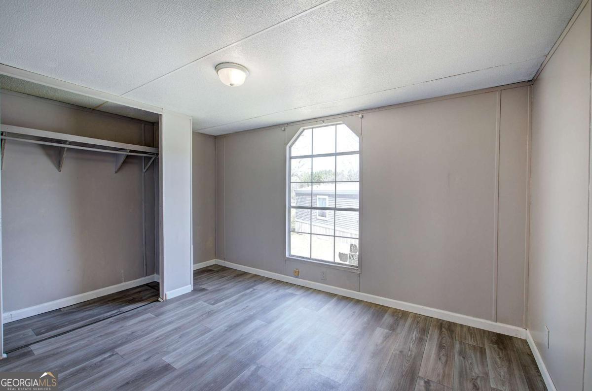 14 High Bluff Road Northeast Rome, GA 30165 - Photo 27 of 29 an empty room with wooden floor and windows