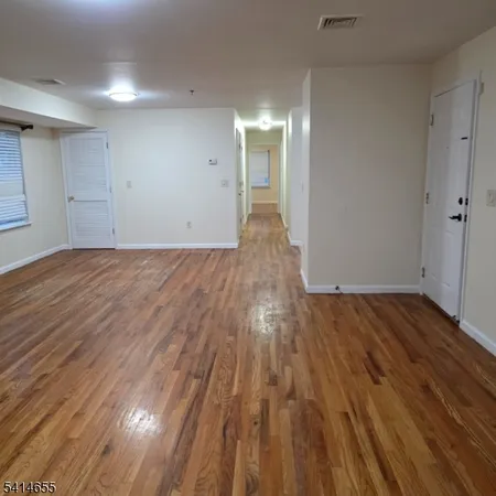 a view of an empty room and wooden floor
