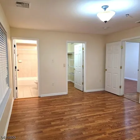 an empty room with wooden floor and cabinet