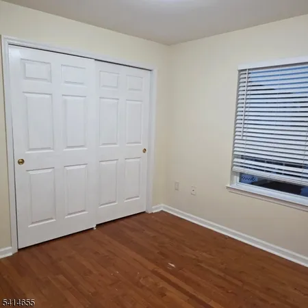 a view of a room with wooden floor and a window