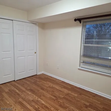 an empty room with wooden floor and cabinet