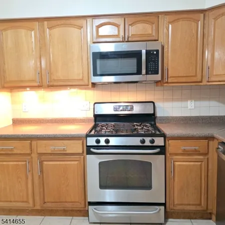 a kitchen with granite countertop a stove microwave and oven