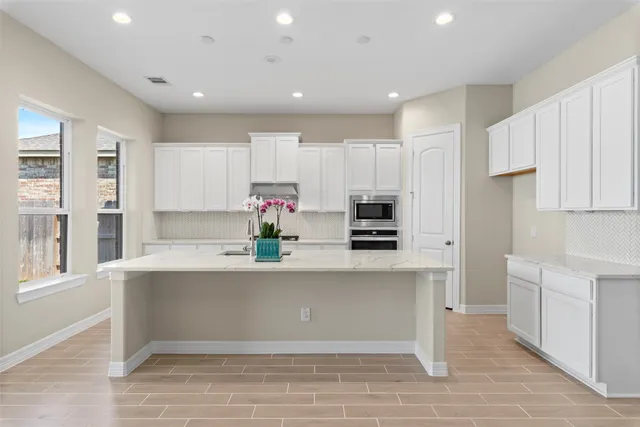 a kitchen with stainless steel appliances a sink a stove a refrigerator and cabinets