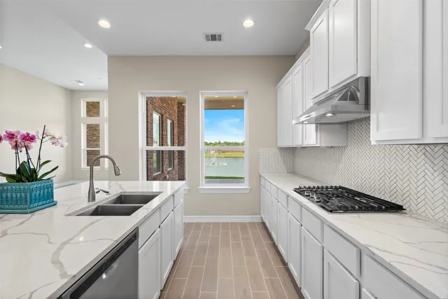 a kitchen with stainless steel appliances a sink a stove and cabinets