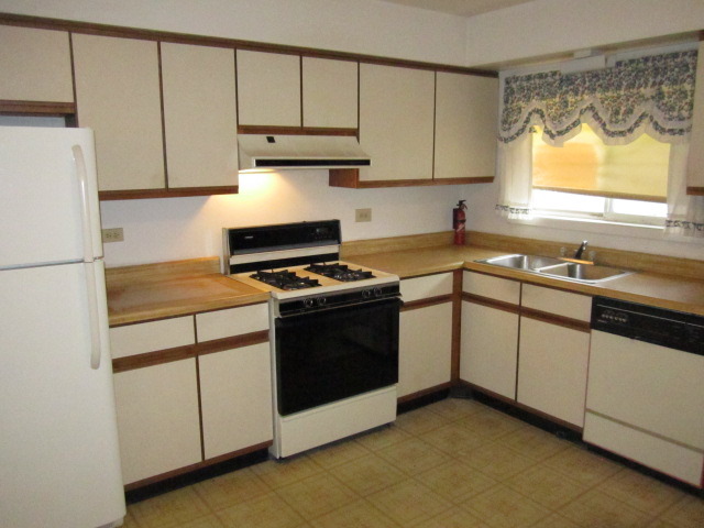 115 East Dundee Road, Unit 2N Wheeling, IL 60090 - Photo 5 of 16 a kitchen with granite countertop a sink a stove and a refrigerator