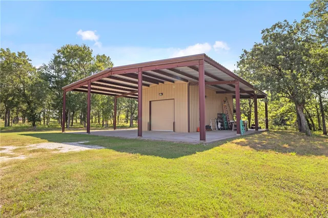 a view of a house with a yard and a large tree