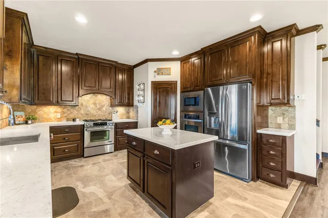 a kitchen with stainless steel appliances granite countertop a stove refrigerator and cabinets