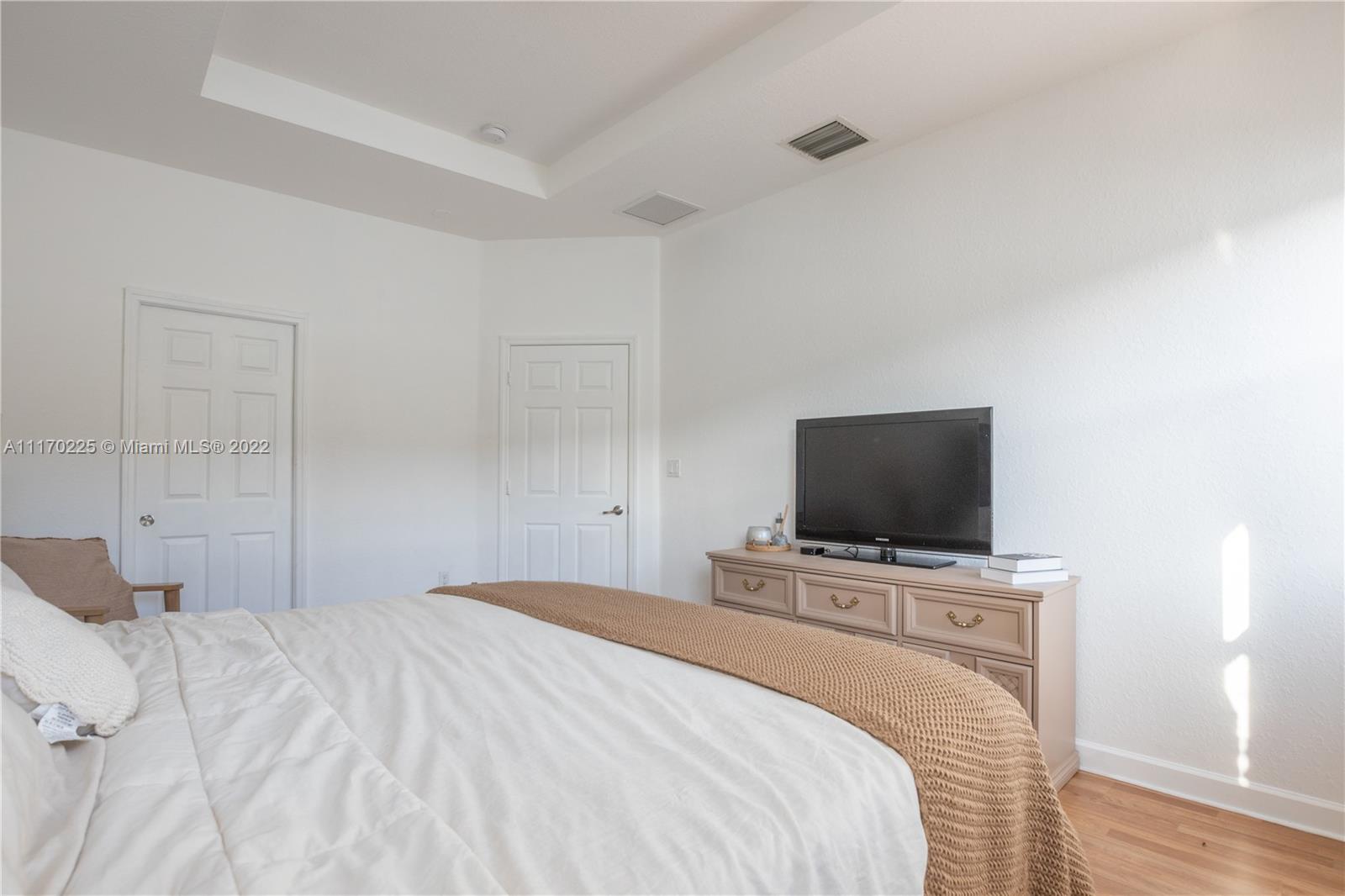 11334 Southwest 236th Street, Unit 11334 Homestead, FL 33032 - Photo 15 of 35 a bedroom with a bed and a flat screen tv