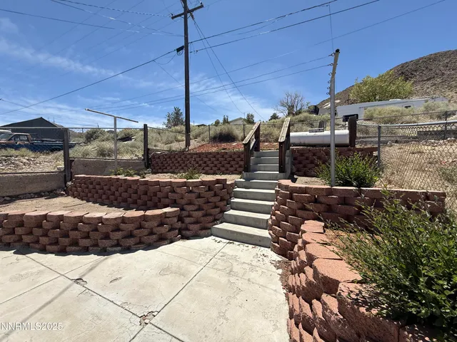 a view of a house with a yard and potted plants