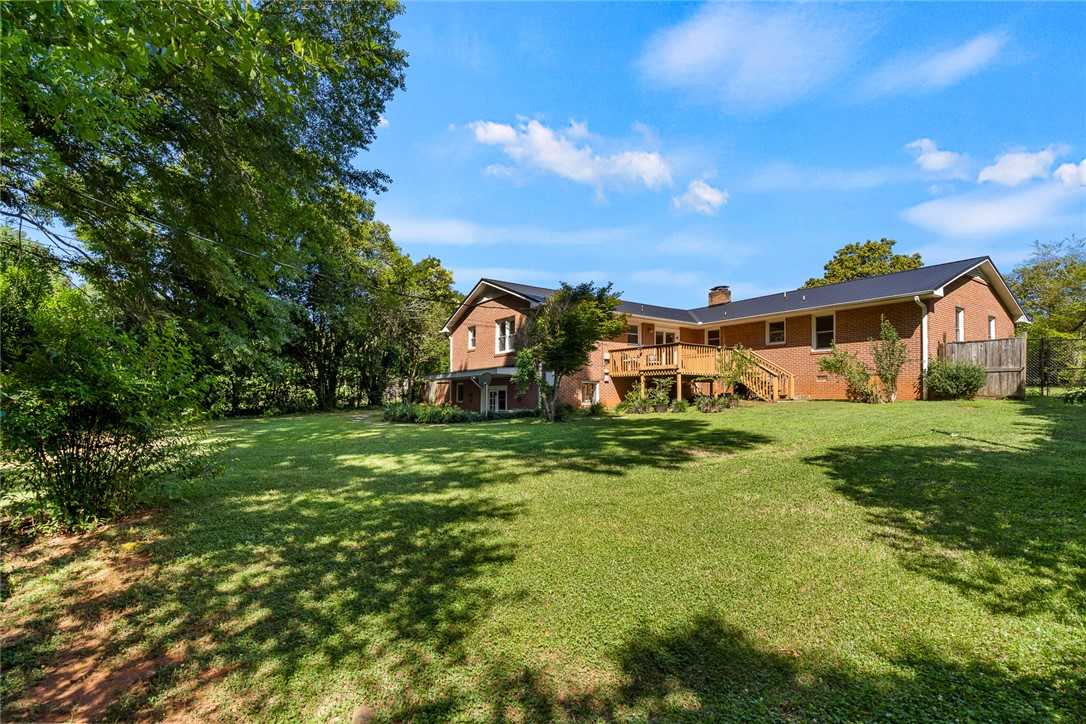 512 East Fredericks Street Anderson, SC 29621 - Photo 29 of 31 An inviting backyard oasis awaits with a spacious deck perfect for gatherings and a sprawling lawn.