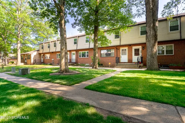 a front view of a house with a yard and trees