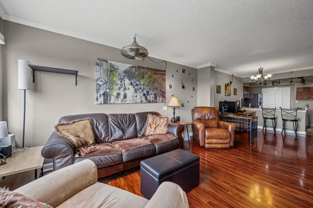 a living room with furniture kitchen view and a chandelier