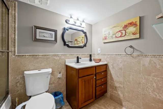 a bathroom with a toilet a sink and mirror