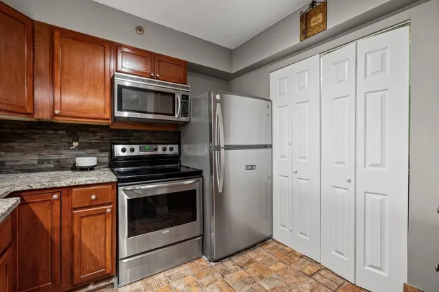 a kitchen with stainless steel appliances granite countertop a refrigerator stove and sink