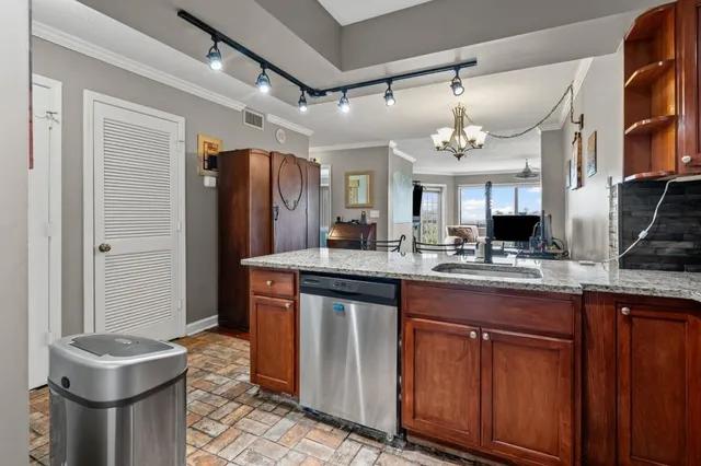 a kitchen with stainless steel appliances granite countertop a sink and wooden cabinets
