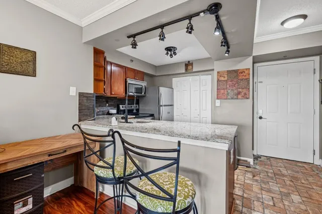 a kitchen with stainless steel appliances granite countertop a sink and a refrigerator