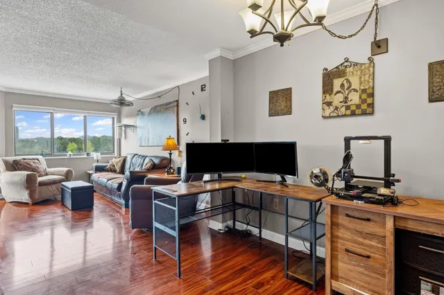 a work room with furniture a flat screen tv and a large window