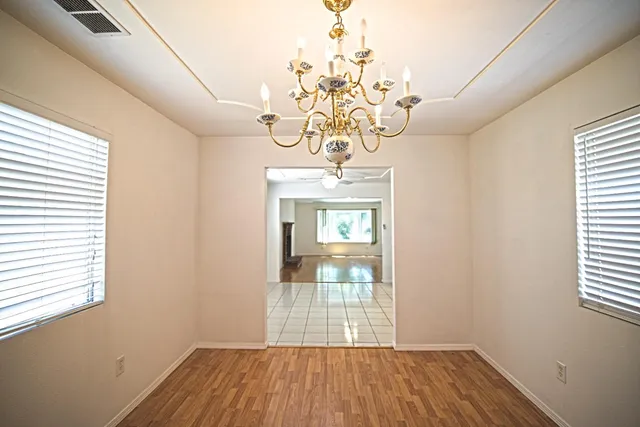 a view of a room with wooden floor and chandelier