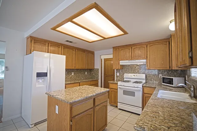 a kitchen with a stove a refrigerator and a sink