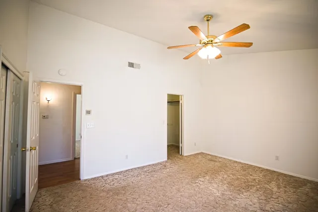 a view of a room with a ceiling fan and closet
