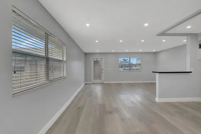 a view of kitchen with center island stainless steel appliances wooden floor and window