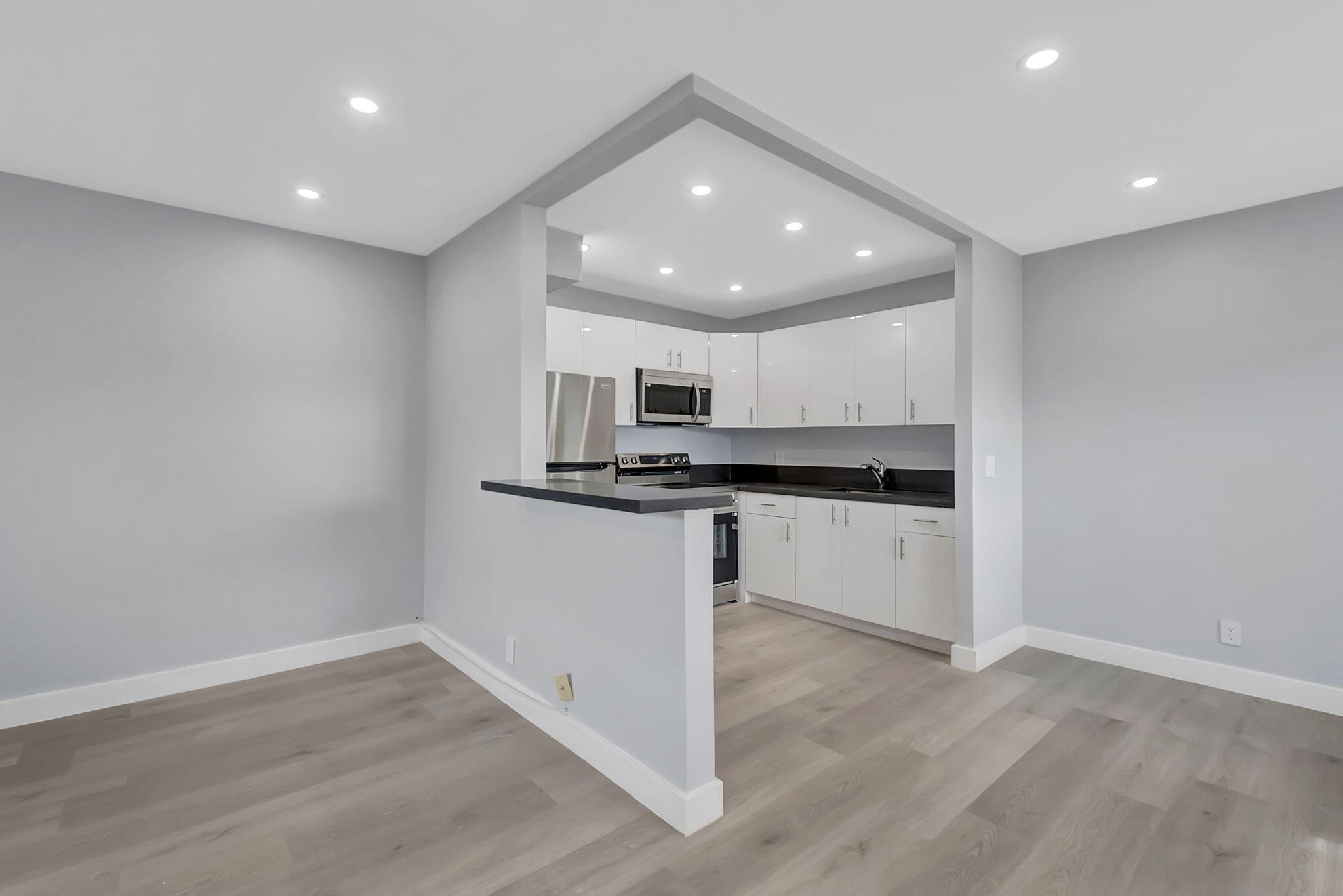 171 Monaco Way Delray Beach, FL 33446 - Photo 14 of 58 a view of kitchen with center island stainless steel appliances wooden floor and window