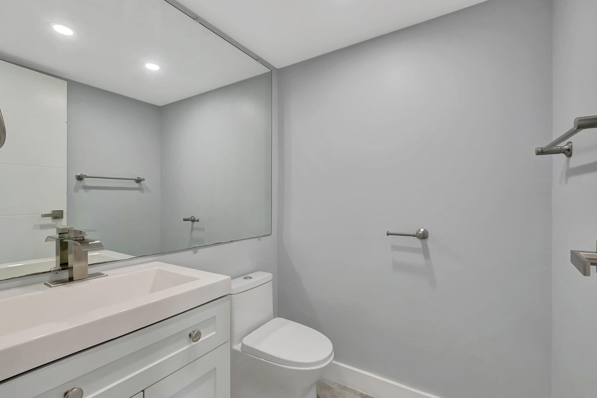 171 Monaco Way Delray Beach, FL 33446 - Photo 17 of 58 a bathroom with a sink a toilet a mirror and vanity