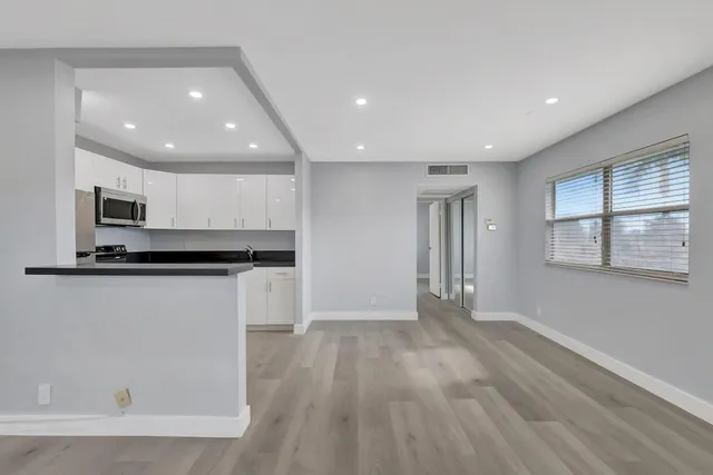 an empty room with windows and cabinet