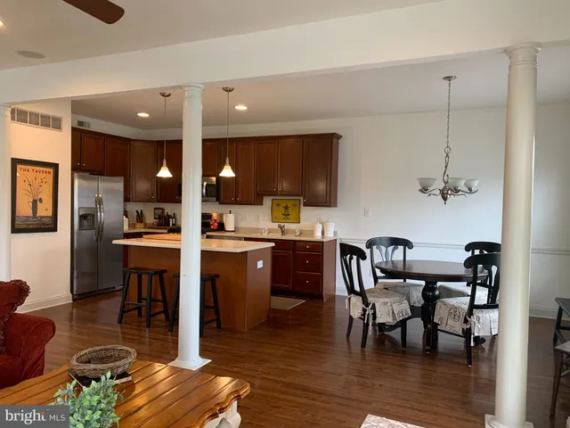 a kitchen with stainless steel appliances granite countertop a stove a sink a microwave a dining table and chairs
