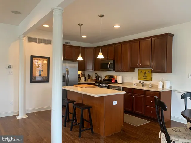 a kitchen with kitchen island granite countertop a sink appliances and cabinets