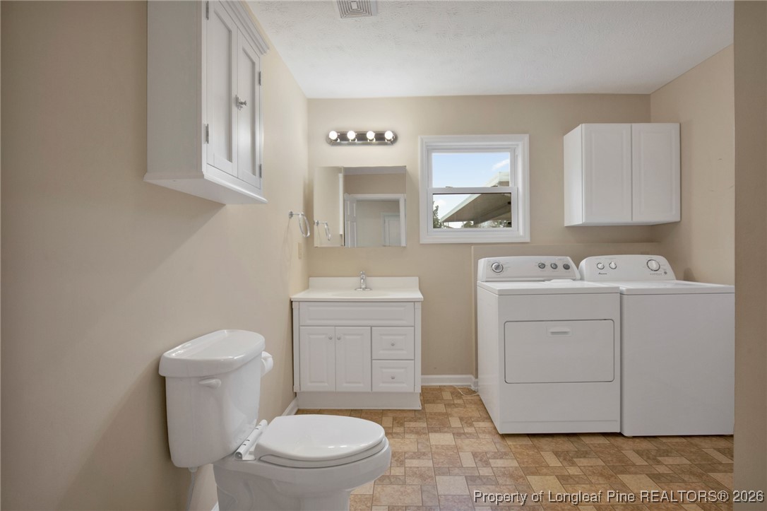 400 Roxie Avenue Fayetteville, NC 28304 - Photo 19 of 33 a bathroom with a toilet sink vanity and mirror
