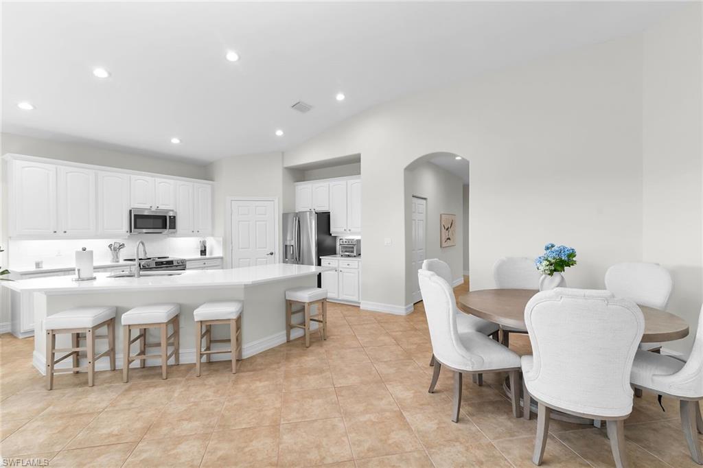 1286 Rialto Way, Unit 9202 Naples, FL 34114 - Photo 9 of 49 Spacious great room featuring vaulted ceilings, recessed lighting, and an effortless transition from the dining area to the beautifully renovated kitchen.