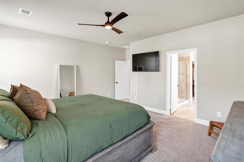5241 Ranchero Trail Fort Worth, TX 76126 - Photo 16 of 29 a bedroom with a large bed and a flat screen tv