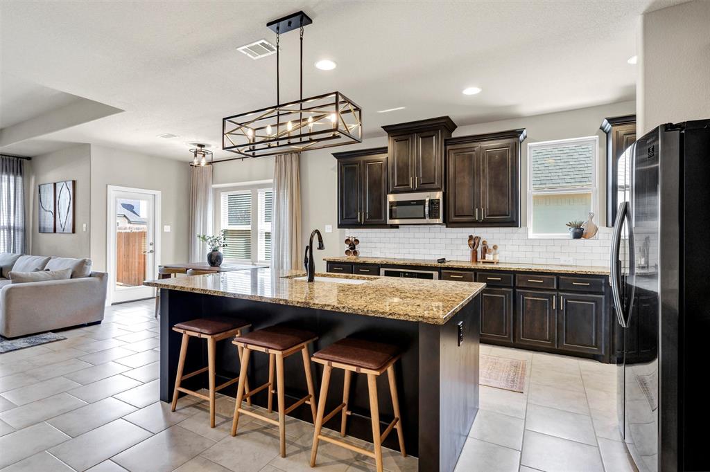 5241 Ranchero Trail Fort Worth, TX 76126 - Photo 29 of 29 a kitchen with stainless steel appliances granite countertop a stove top oven a sink dishwasher a dining table and chairs with wooden floor