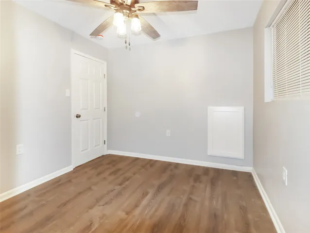 an empty room with a window and a chandelier fan