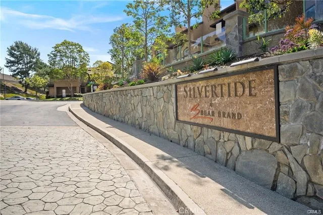a view of a sign board with buildings in the background