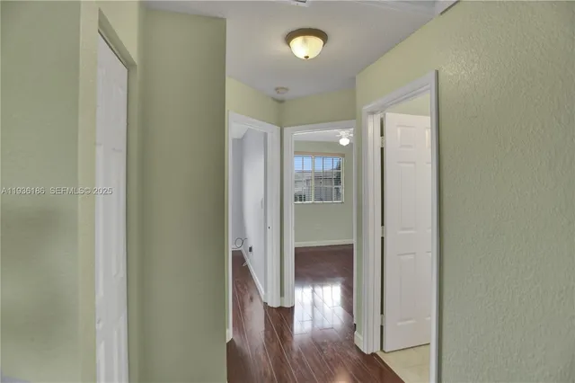 a view of a hallway with wooden floor