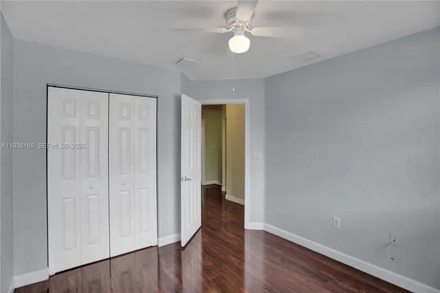 an empty room with wooden floor and entrance