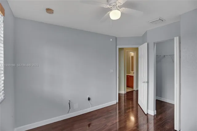 an empty room with wooden floor and closet