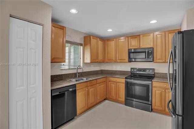 a kitchen with stainless steel appliances granite countertop a stove a sink and a refrigerator