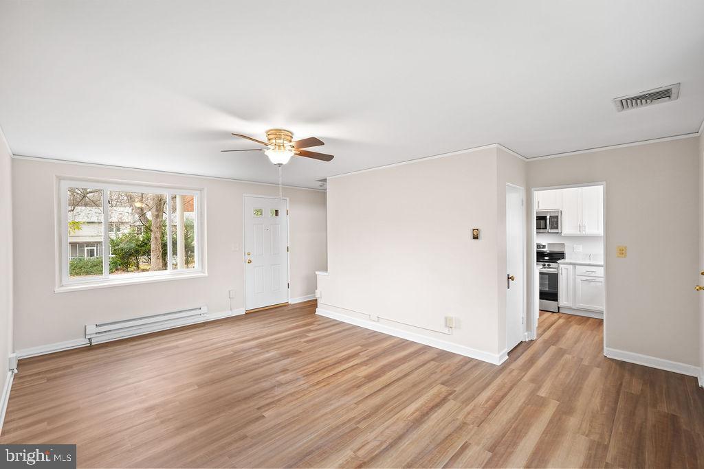 13 Ridge Road Greenbelt, MD 20770 - Photo 21 of 32 an empty room with wooden floor and windows