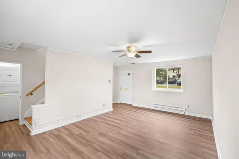 an empty room with wooden floor and staircase