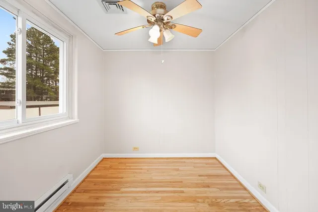 a view of a room with wooden floor and a window