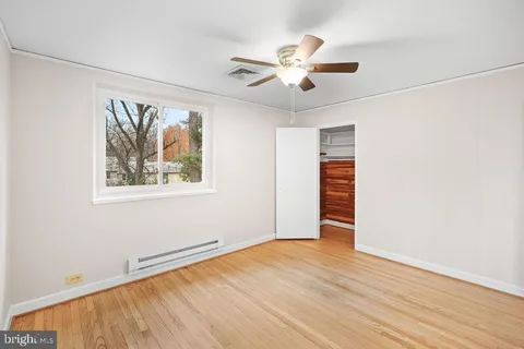 a view of empty room with wooden floor