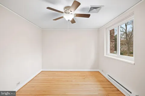 an empty room with a window and a ceiling fan